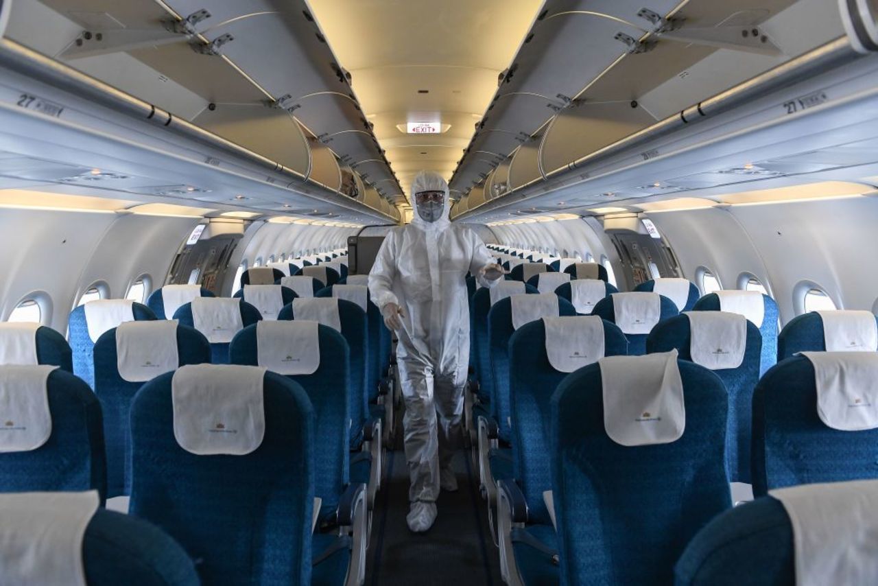 A worker wearing a protective suit disinfects a Vietnam Airlines plane at Noi Bai International Airport in Hanoi on Tuesday.