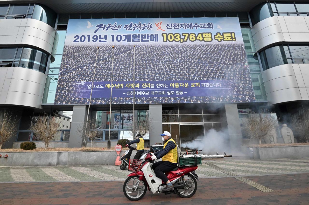 South Korean health officials spray disinfectant in front of the Daegu branch of the Shincheonji Church of Jesus in Daegu, South Korea, on February 21.