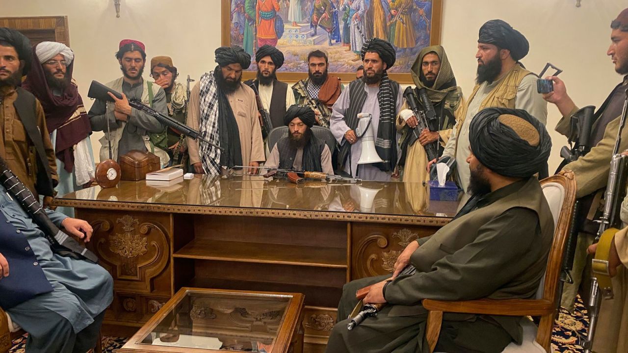 Taliban fighters sit inside the presidential palace in Kabul on August 15.