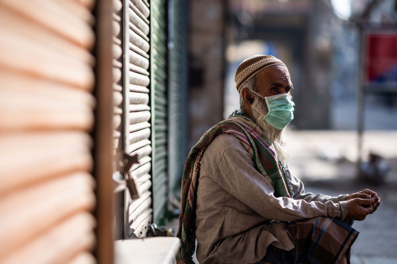 A man wearing a face mask sits in front of a closed shop during a government-imposed nationwide lockdown in New Delhi, India, on April 6.