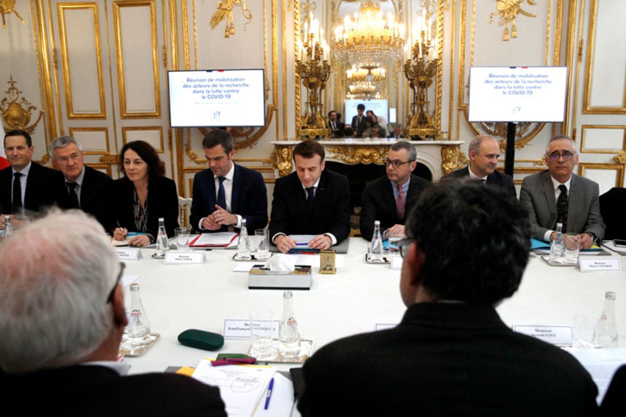 French President Emmanuel Macron, center, and Health minister Olivier Veran, centre left, hold a meeting with with researchers and scientists about the COVID-19 outbreak, at the Elysee Palace in Paris, France, Thursday, March 5.