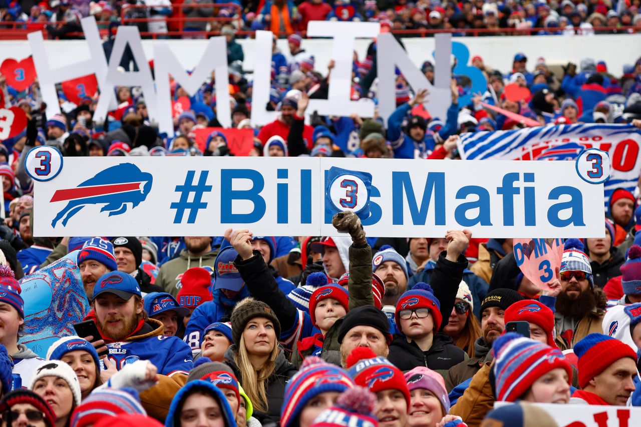 Fans hold signs in support of Damar Hamlin on Sunday.
