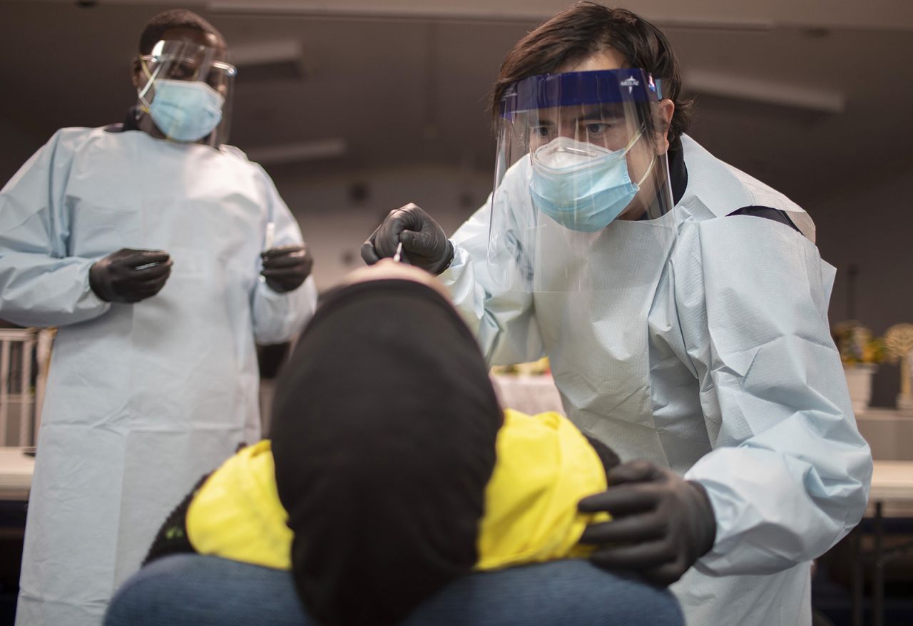 In this July 22, 2020 file photo, health care workers use a nasal swab to test a person for Covid-19 at a pop up testing site at the Koinonia Worship Center and Village in Pembroke Park, Florida. 