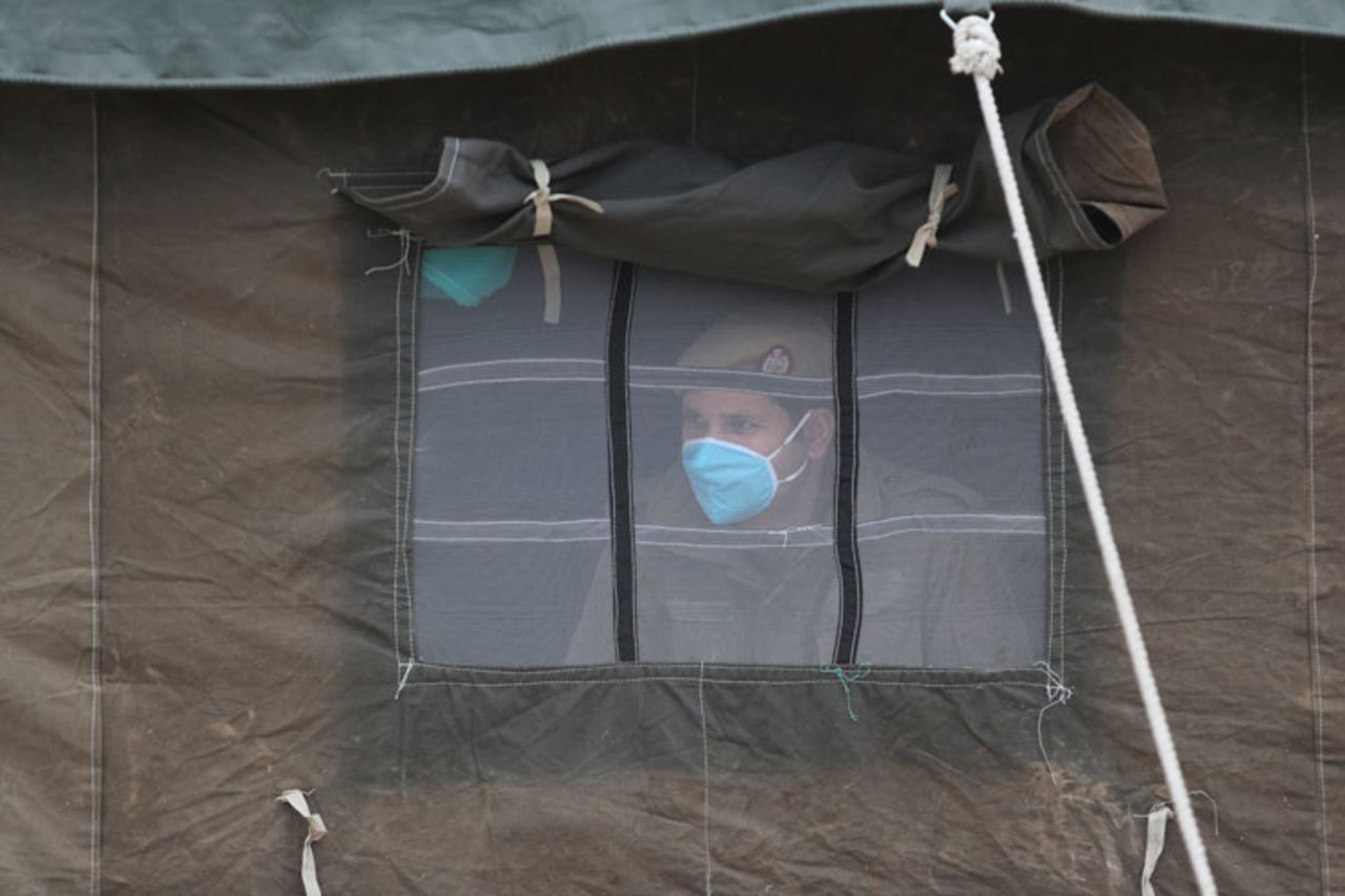 An Indian policeman looks out from a tent at an isolation ward set up for possible coronavirus patients in Jammu, India, on Wednesday, March 11.