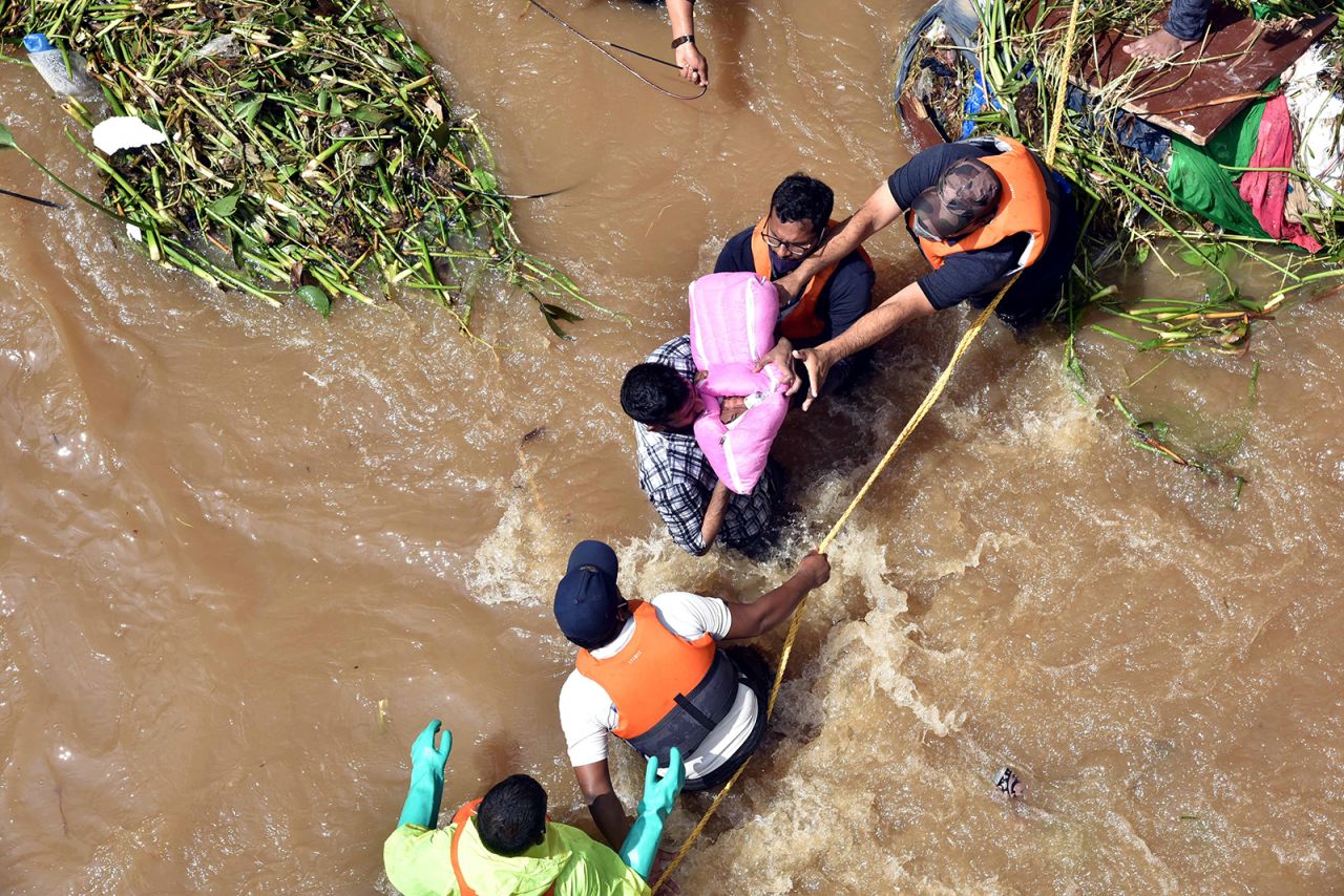 National Disaster Response Force personnel rescue a baby and her family from a waterlogged house at Hafiz Baba Nagar at Hyderabad in India's southern state of Telangana, on October 18.