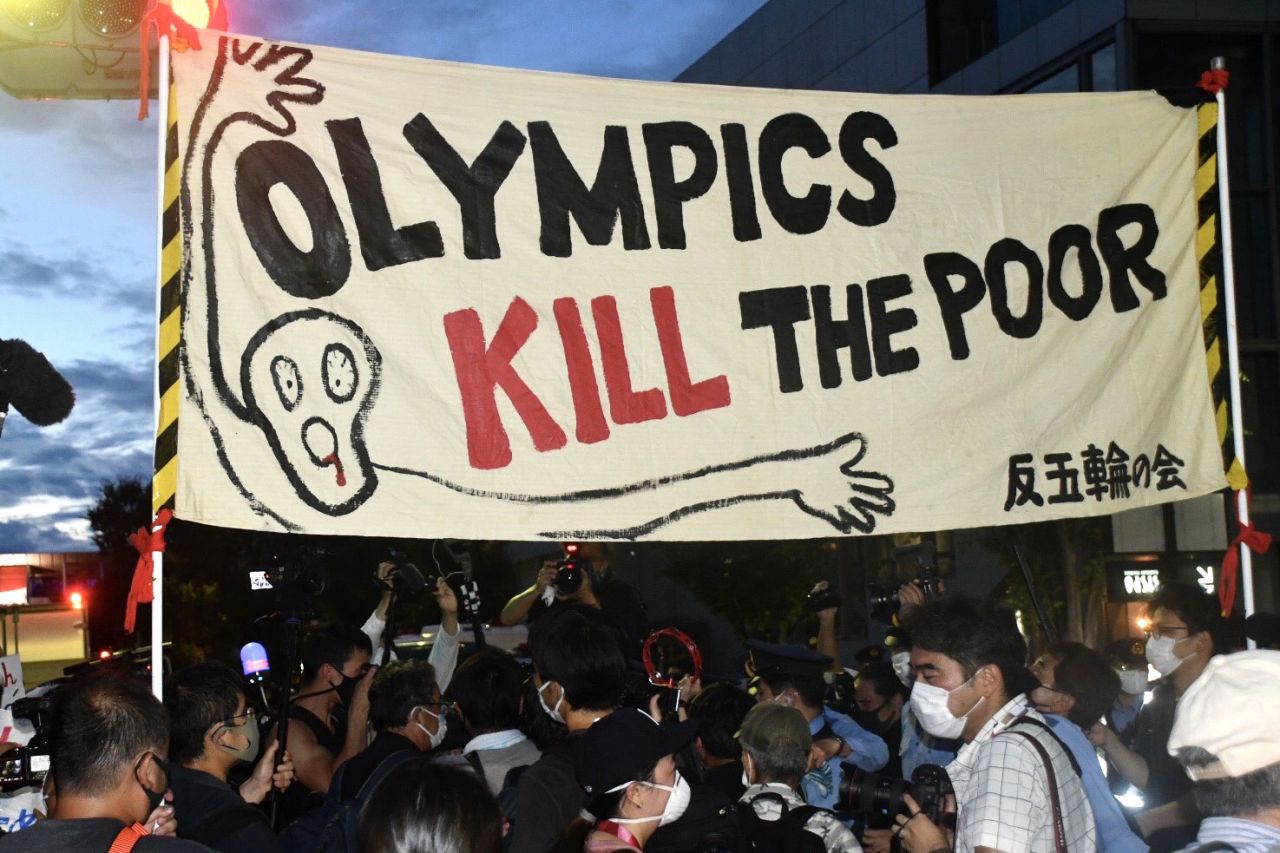 A banner with the message "Olympics kill the poor" is seen during a protest outside the National Stadium in Tokyo, before the closing ceremony on August 8, 2021.