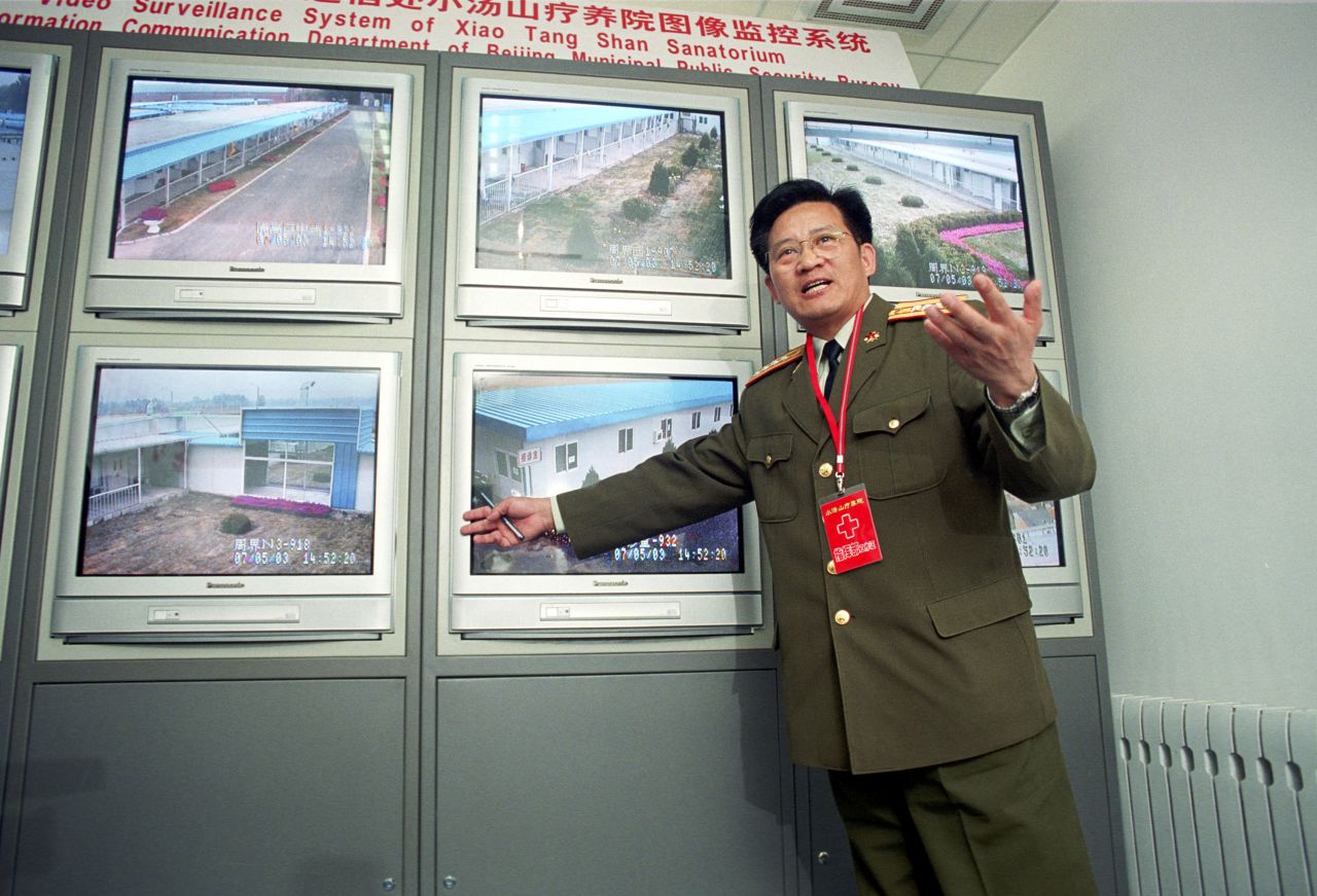 A military official explains the surveillance system of a newly built 1,000 bed SARS hospital to journalists on May 7, 2003 in Xiaotangshan, near Beijing, China.