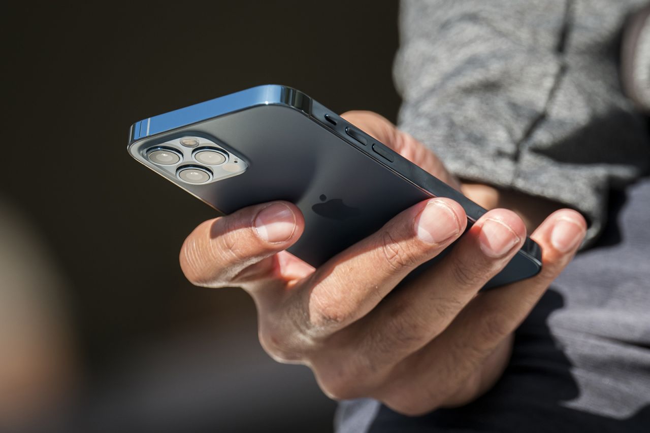 A customer holds an iPhone 12 Pro at an Apple store in San Francisco in October 2020. 