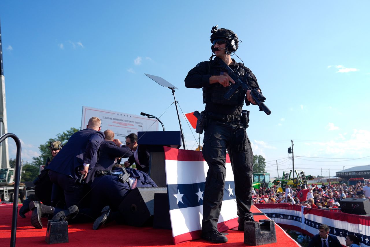 Secret Service agents cover former President Donald Trump at a campaign rally on July 13, in Butler, Pennsylvania.