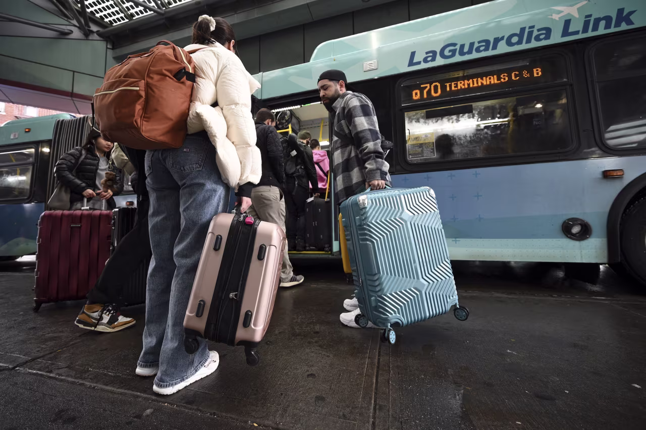 Travelers board a bus to LaGuardia Airport in New York City on Wednedsay.