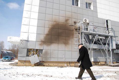 A man walks past a damaged part of the National Science Center, Kharkiv Institute of Physics and Technology on Friday.