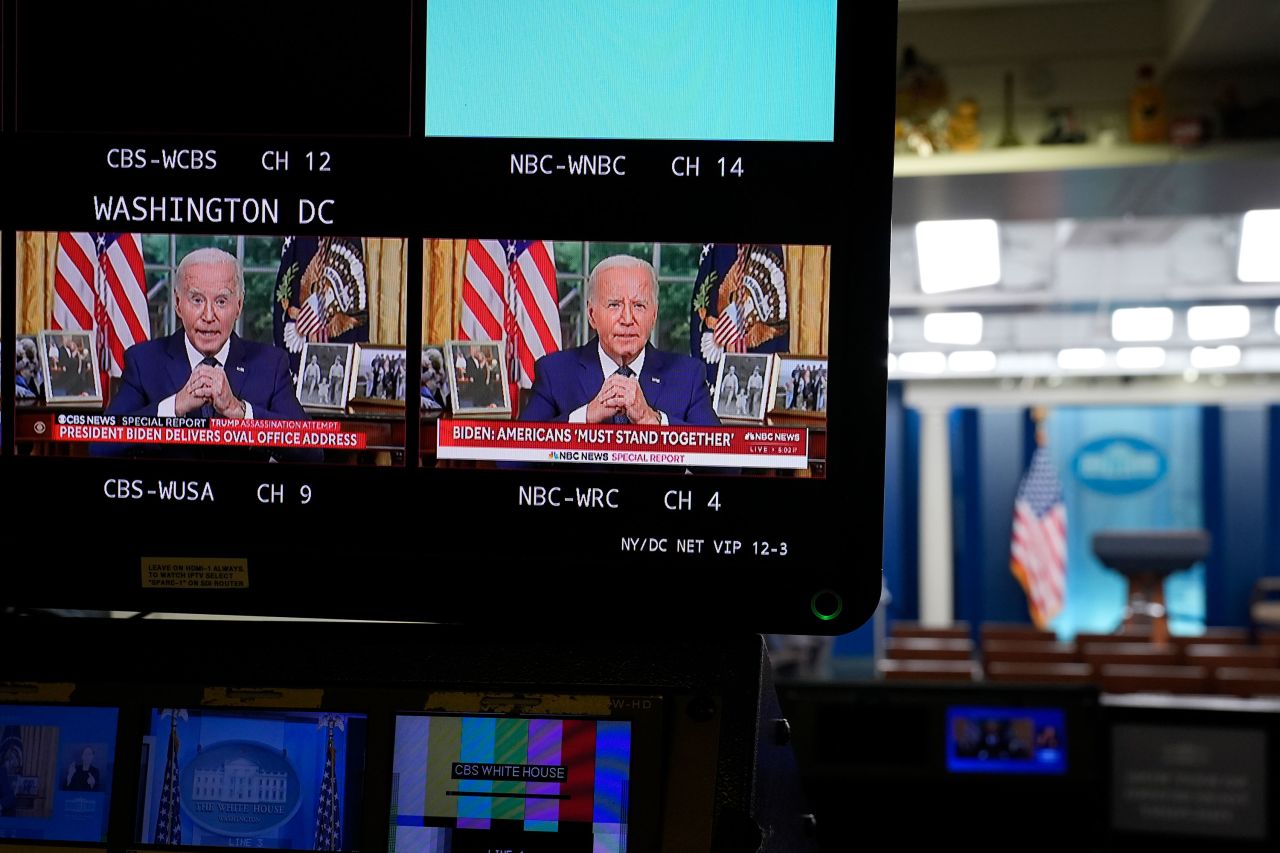 President Joe Biden is seen on monitors in the press briefing room of the White House on Sunday night as he addresses the nation from the Oval Office.