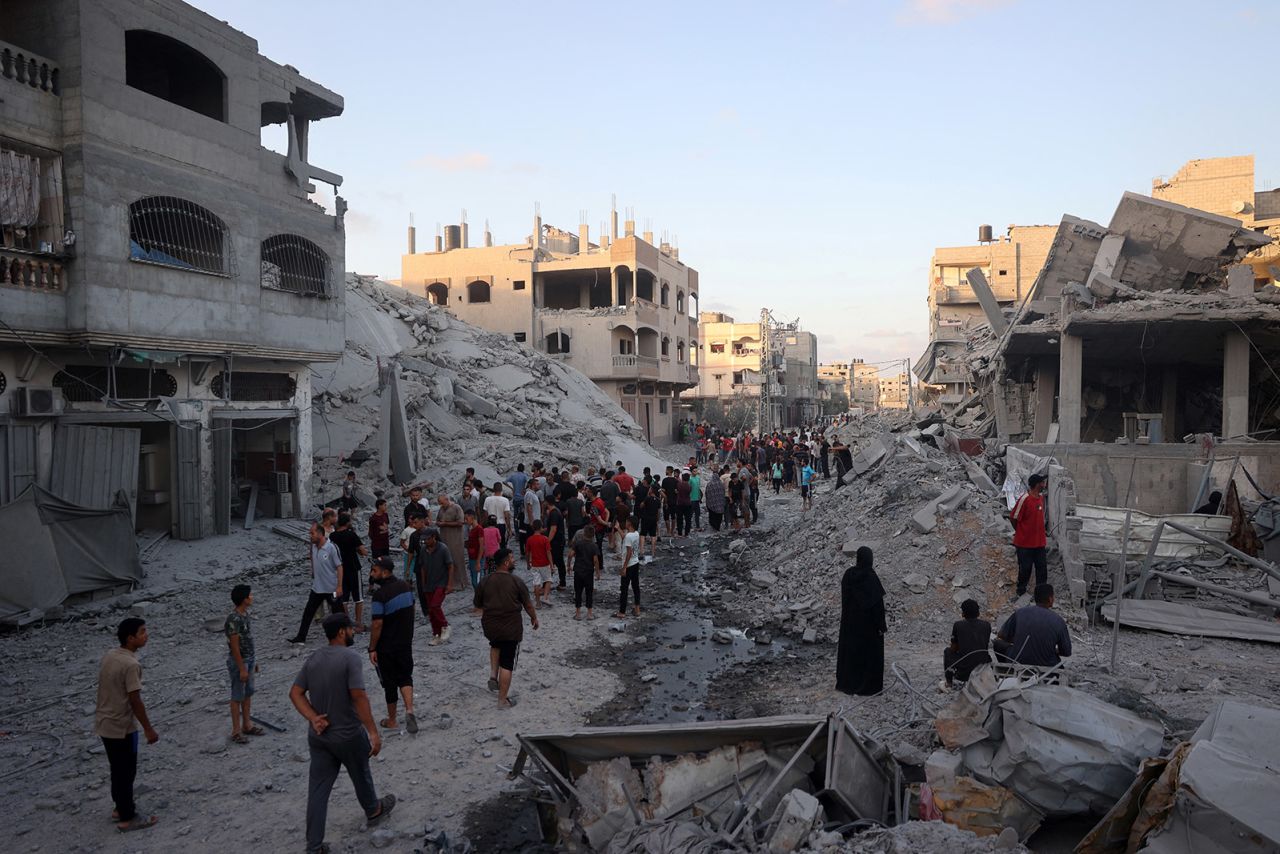 Palestinians gather to check a building after Israeli bombing in the Nuseirat refugee camp in the central Gaza Strip on August 22. 