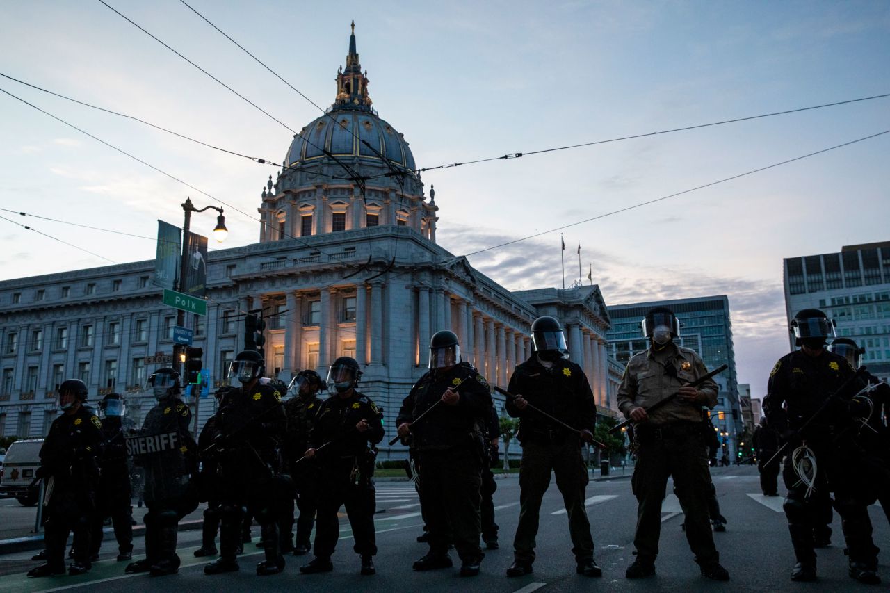 Police officers stand guard in front of San Francisco's City Hall on Sunday, May 31.