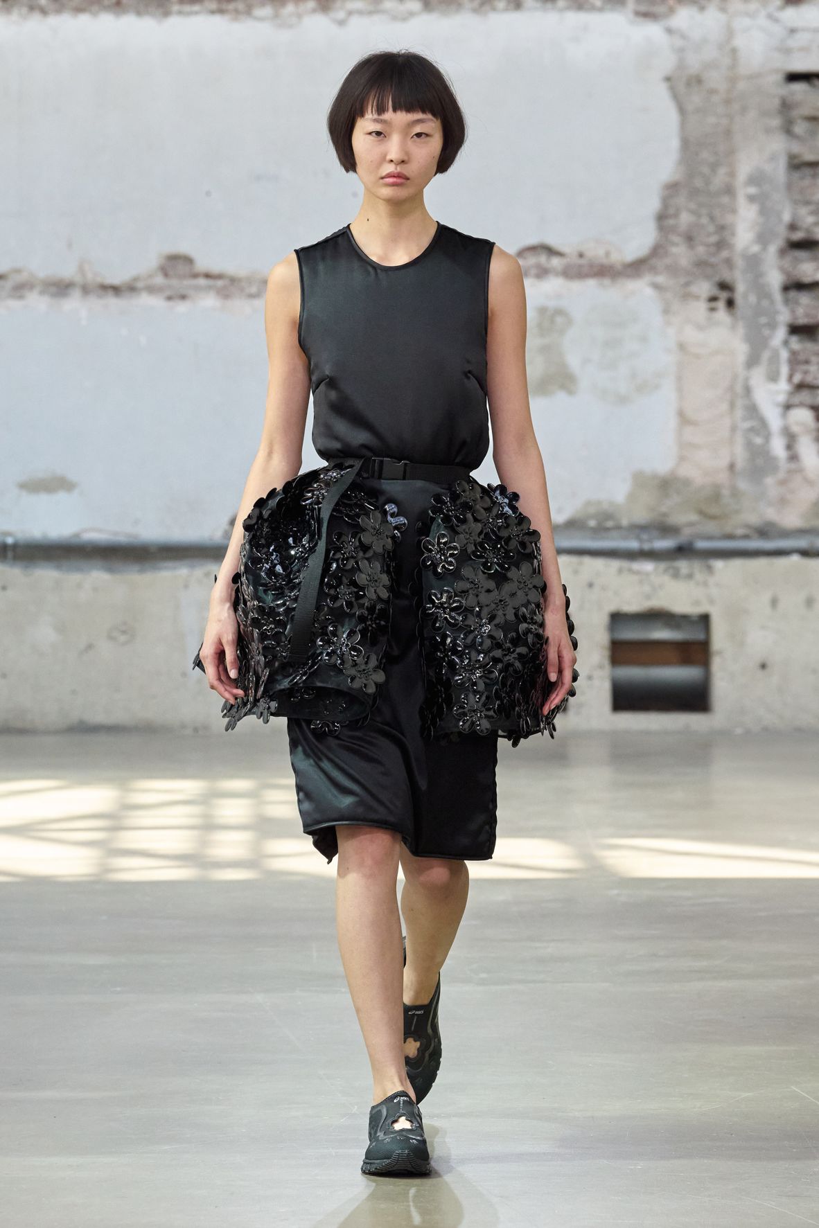 Danish designer Cecilie Bahnsen played with large plastic flowers to create an oversized broderie anglaise-inspired motif (a traditional form of cut-out embroidery used to create floral patterns). The flowers were created with a custom mold, adorned onto voluminous skirts and dresses with metal studs.