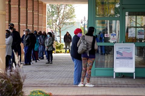 People wait in line during early voting at Des Plaines Public Library in Des Plaines, Illinois, Wednesday, October 21. 