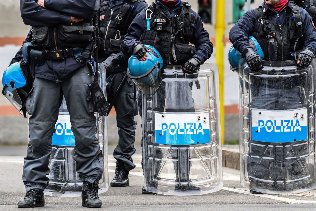 Anti-riot police officers stand guard outside the San Vittore prison in Milan as inmates stage a protest on a rooftop of a wing at the prison on March 9, in one of Italy's quarantine red zones.