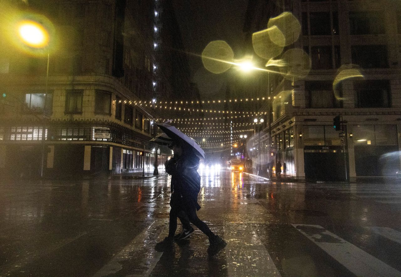 People walk during heavy rains in downtown Los Angeles on Sunday, February 4. 