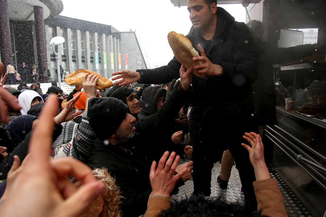 People hand out food to survivors in the Pazarc?k district of Kahramanmara?, Turkey.