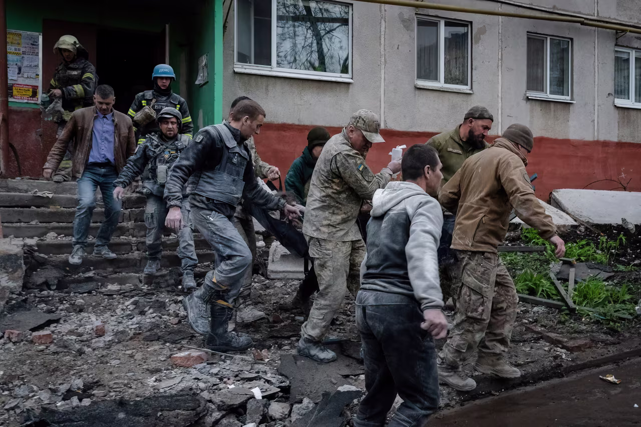 Military officials and firefighters rescue people following a rocket attack in Sloviansk, Ukraine, on April 14.