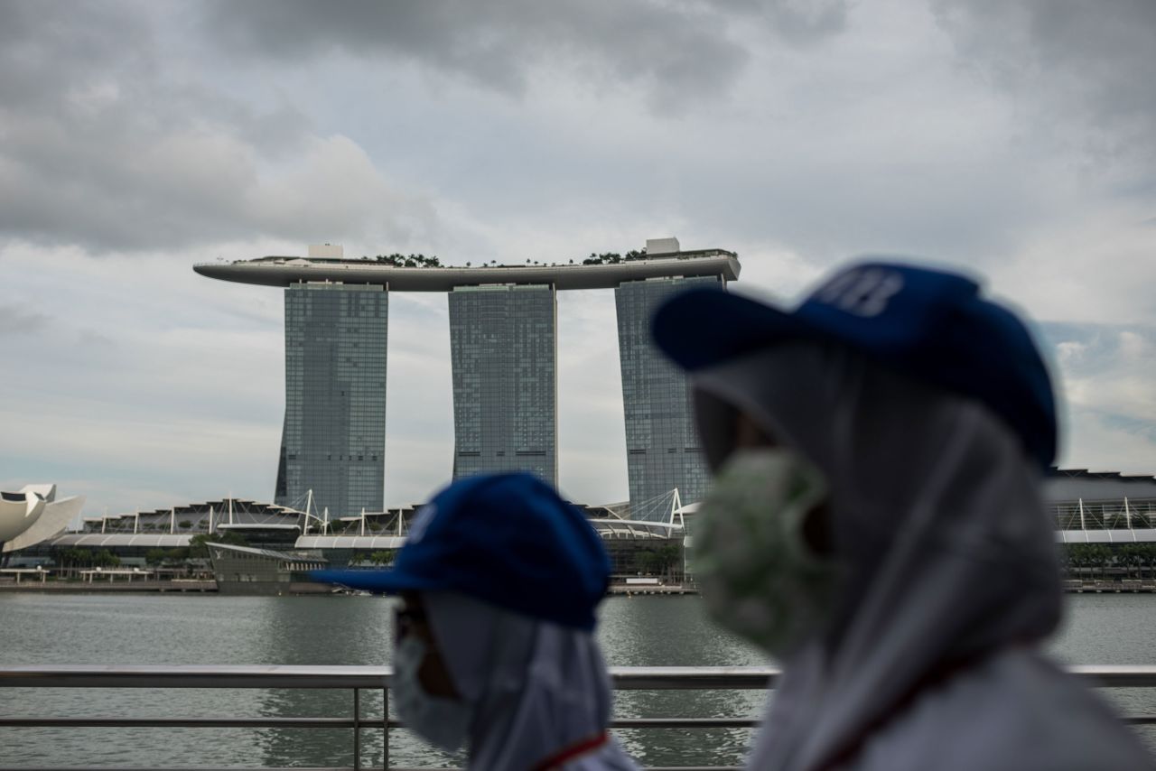 People wearing protective masks walk towards Merlion Park in Singapore on February 12.