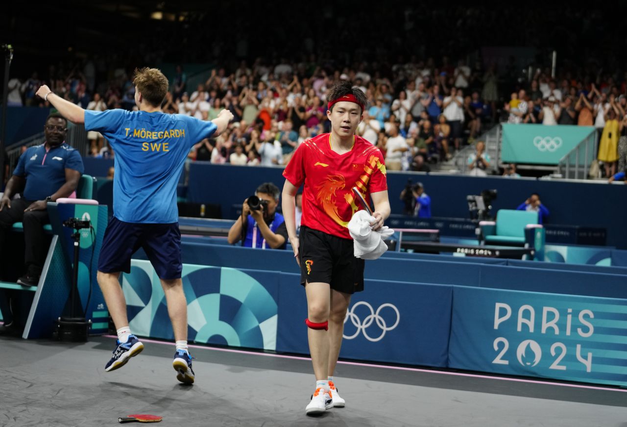 Sweden's Truls Möregårdh, left, reacts after his win against China's Wang Chuqin, right, in a round of 32 table tennis game on Wednesday.