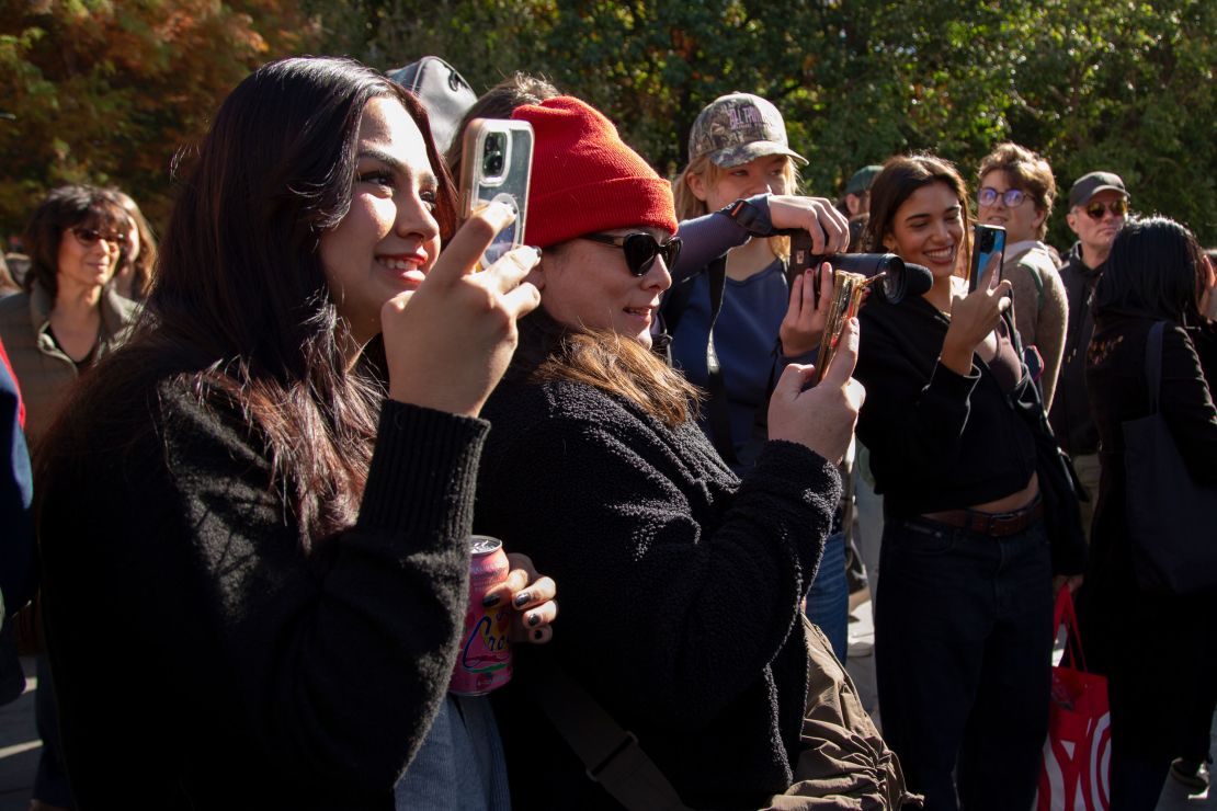 Alondra Maldonado, 19, left, takes pictures of her boyfriend Reed Putnam as he is interviewed.