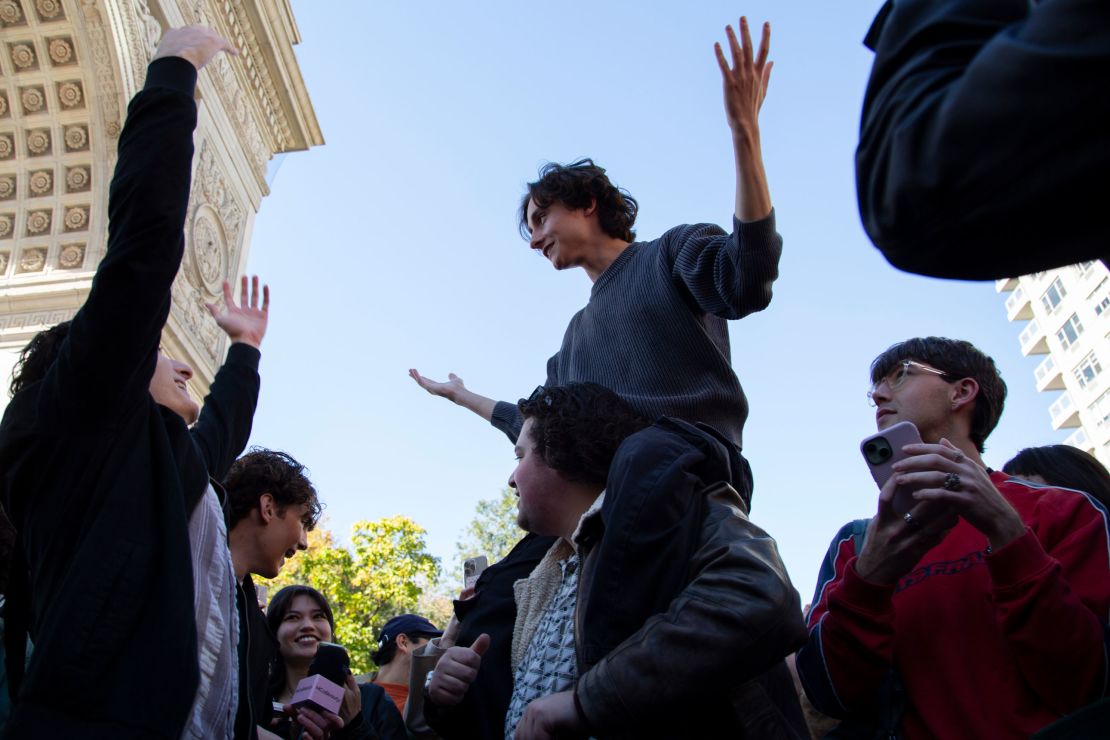 Spencer DeLorenzo is lifted up among the crowd of Timothée Chalamet lookalikes, fans and police.