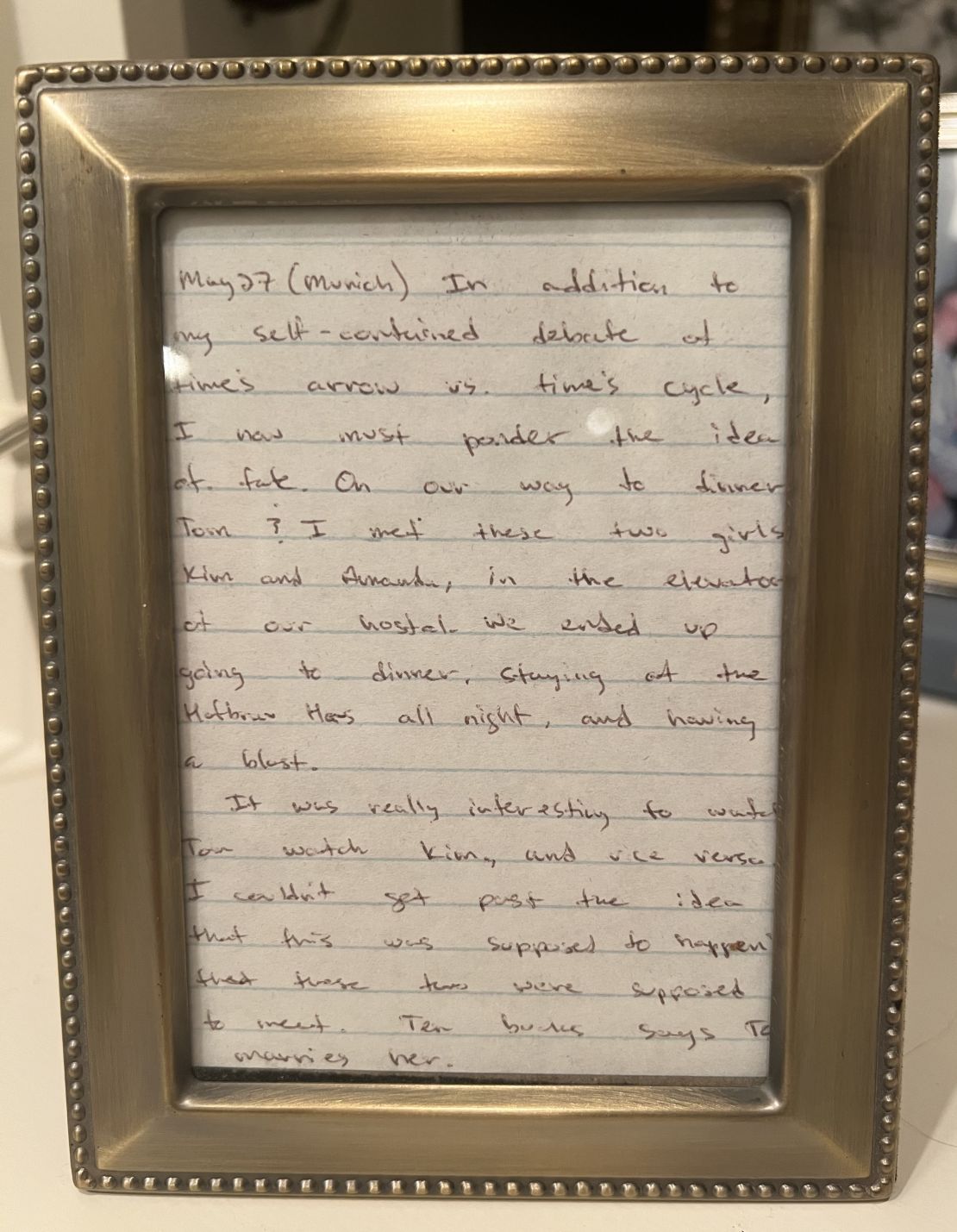 A framed excerpt from John's travel journal, which describes the moment Tom and Kim first met. "Ten bucks says Tom marries her," wrote John that day in 1998.