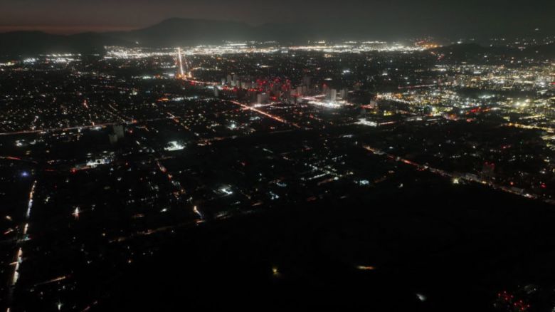 Esta vista aérea muestra la ciudad parcialmente iluminada durante un apagón en Santiago el 25 de febrero de 2025.