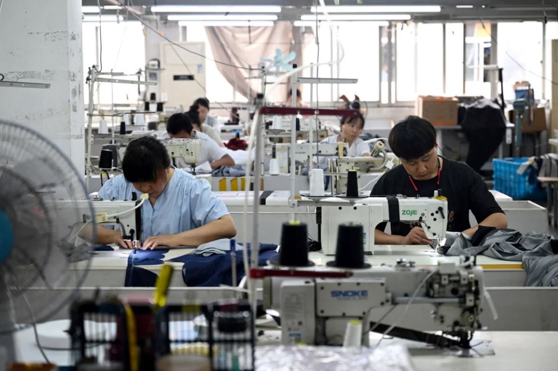 Trabajadores cosen ropa en un parque industrial textil en Shaoxing, provincia oriental china de Zhejiang, el 9 de mayo.