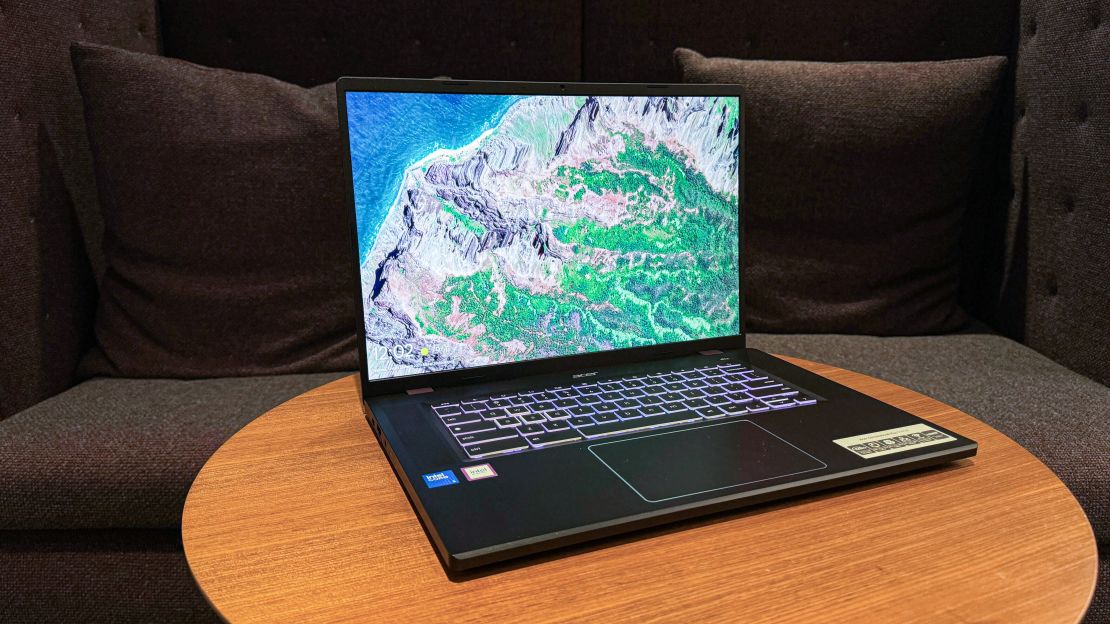 the Acer Chromebook Plus 516GE is open on a table with an overhead landscape view background