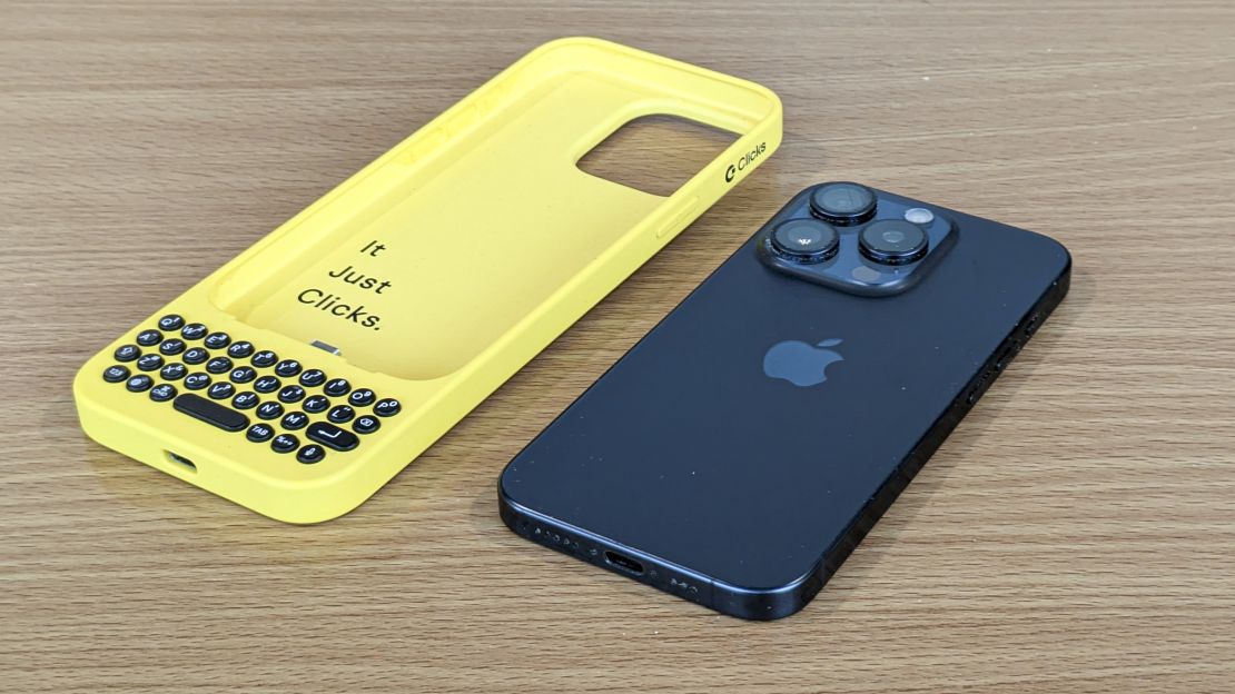 Yellow Clicks keyboard case next to black iPhone 15 Pro.