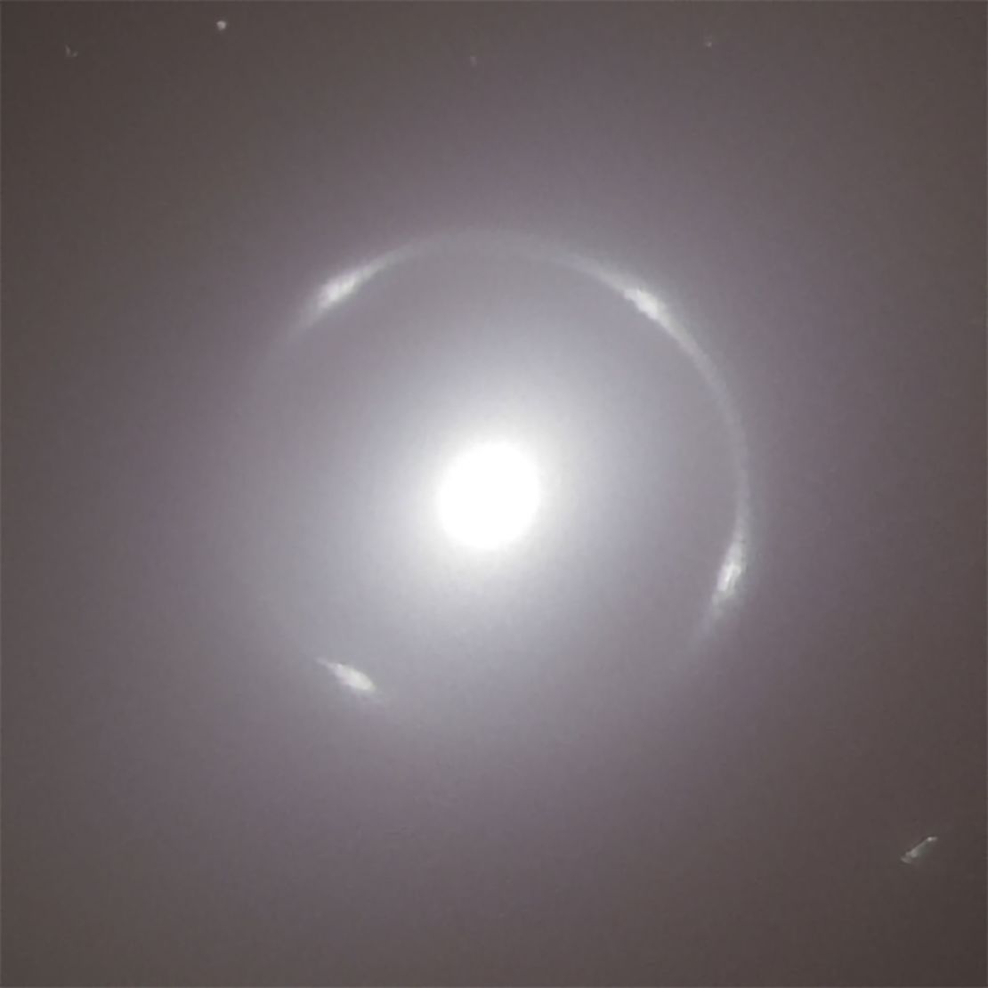 A close-up view of the center of the NGC 6505 galaxy showcases the bright Einstein ring surrounding it.