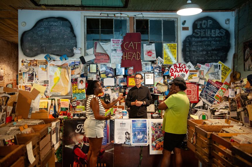 <strong>Blues and folk art: </strong>Roger Stolle (center), owner of Cat Head Delta Blues & Folk Art, chats with customers at his shop in Clarksdale in June.