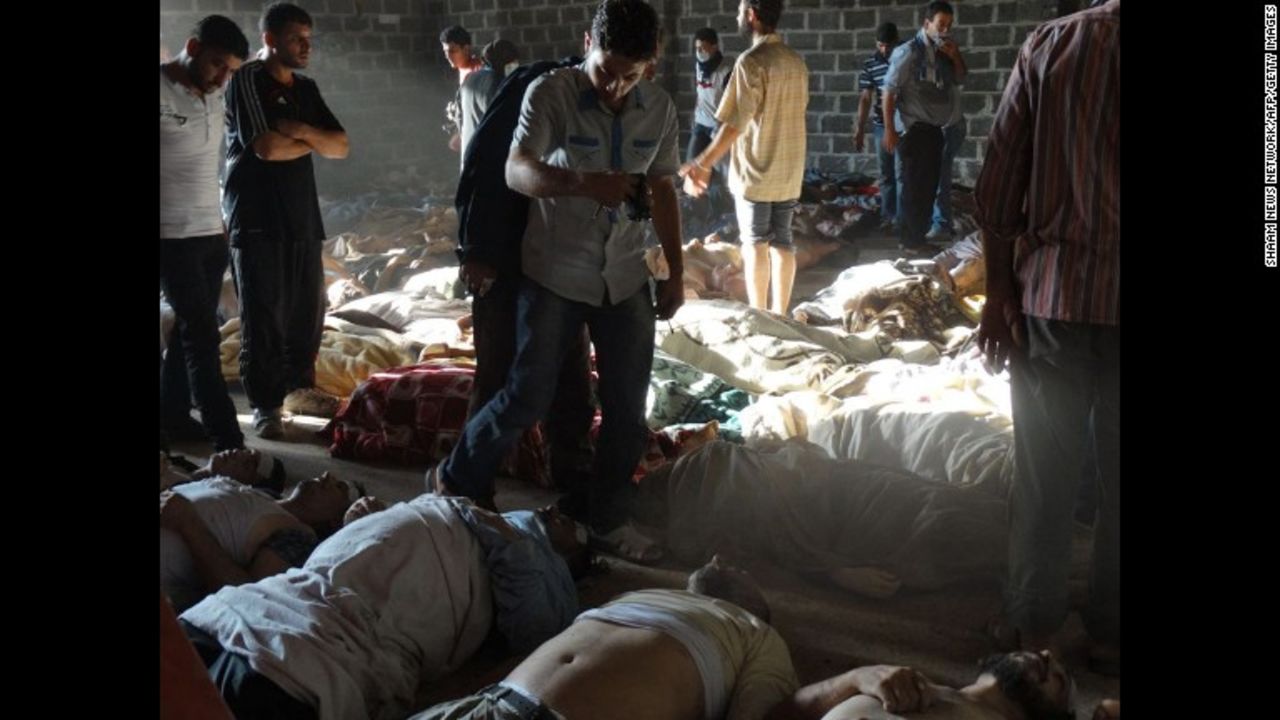 People inspect bodies of children and adults laying on the ground after they were killed, Syrian rebels claim, in a chemical attack by pro-government forces in eastern Ghouta, on the outskirts of Damascus on August 21, in this photo released by the Syrian opposition's Shaam News Network.