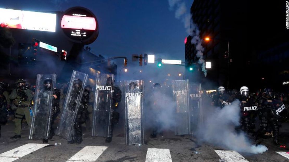 La policía de Atlanta se prepara para aplicar el toque de queda a las 9:00 pm con gases mientras los manifestantes cantan.