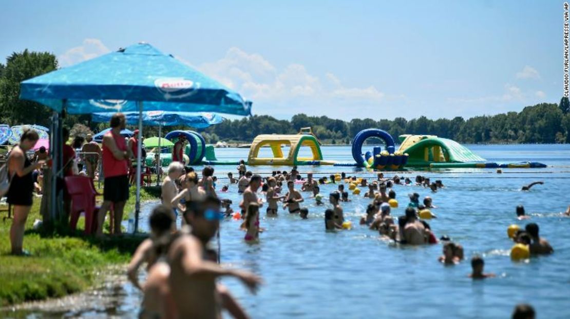 Personas nadan en un lago artificial en Milán el 12 de julio.