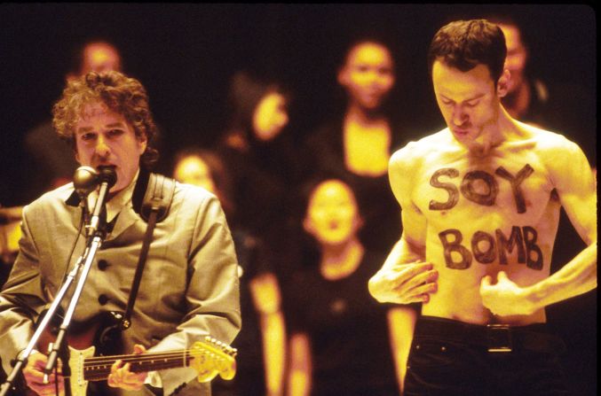 Dylan interpreta "Love Sick" junto al artista de performance Michael Portney en los premios Grammy de 1998. Portnoy había sido contratado como parte de los bailarines de fondo para la actuación, pero su irrupción sin camisa no estaba planeada y fue sacado del escenario. Kevin Mazur / WireImage / Getty Images