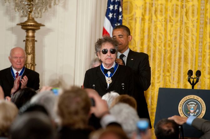 Dylan recibe la Medalla Presidencial de la Libertad de manos del presidente Barack Obama en 2012. "Recuerdo, ya saben, en la universidad, escuchar a Bob Dylan y mi mundo abrirse, porque capturó algo sobre este país que era tan vital", dijo Obama. Leigh Vogel / WireImage / Getty Images