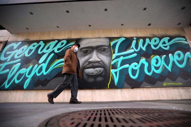 Un hombre pasa junto a un mural de Floyd en un edificio de oficinas en Oakland, California, el 29 de marzo de 2021.