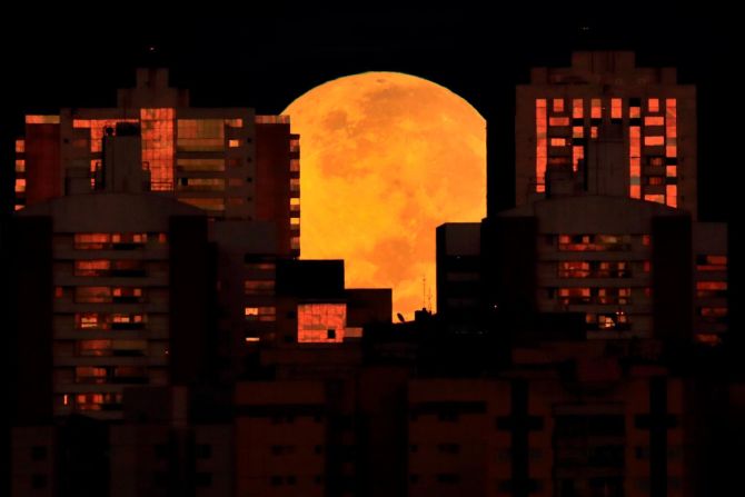 La luna se ve parcialmente cubierta por edificios en Brasilia, Brasil, al comienzo del eclipse lunar del miércoles. Eraldo Peres / AP