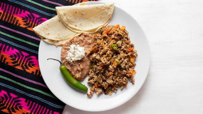 Machaca con huevos: esta receta mexicana agrega carne desmenuzada seca a una mezcla de huevos, cebollas, tomates y chiles. Shutterstock