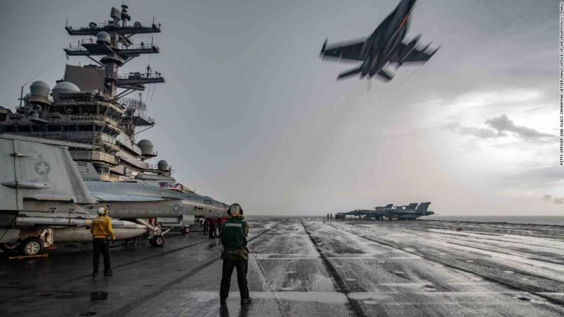Un caza F/A-18E Super Hornet vuela por el encima de la cubierta del USS Ronald Reagan en 2020.