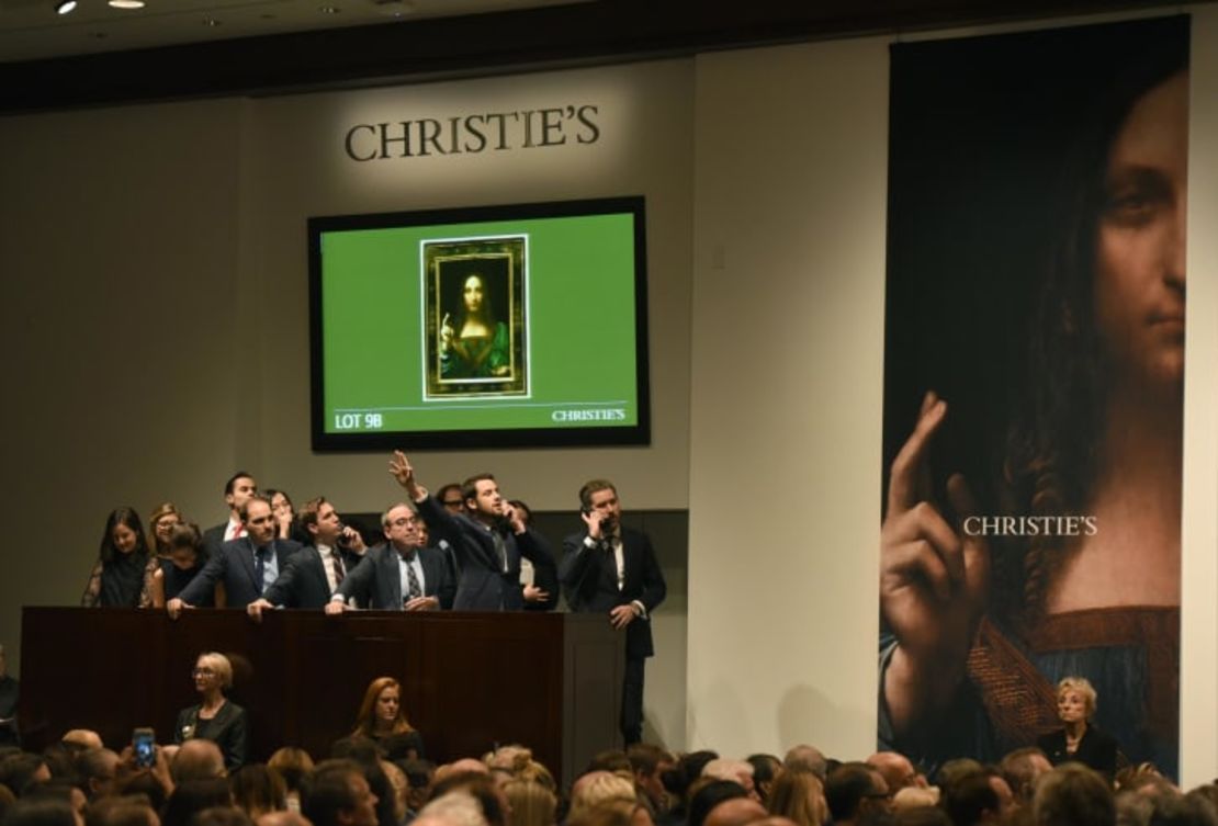 Empleados de Christie's escuchan ofertas por el "Salvator Mundi" de Leonardo da Vinci en la subasta de Christie's en Nueva York en noviembre de 2017. Crédito: Timothy A. Clary/AFP/Getty Images