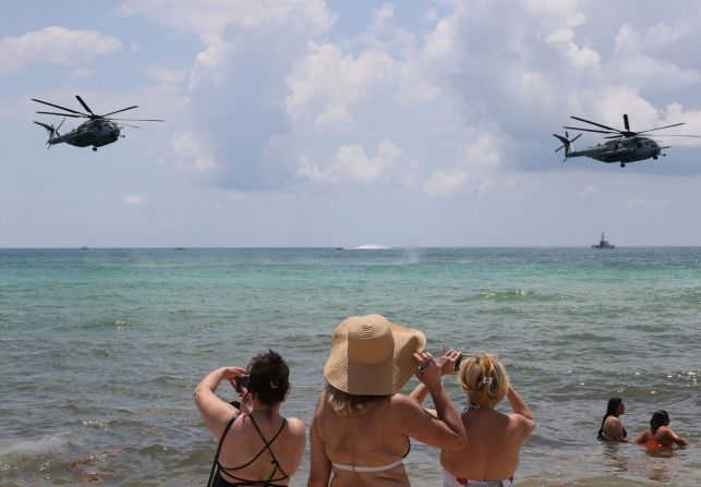 Personas en la playa observan cómo los helicópteros de la Marina de EE.UU. practican maniobras el viernes para un espectáculo aéreo y marítimo en Miami Beach, Florida. Joe Raedle / Getty Images