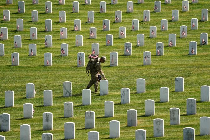Un soldado coloca una bandera como parte de la ceremonia Flags In en el Cementerio Nacional de Arlington el jueves 27 de mayo. Más de 1.000 miembros del servicio colocaron banderas frente a más de 260.000 lápidas. Kevin Lamarque / Reuters