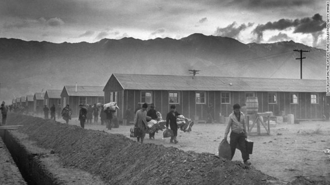 El primer grupo de 82 japoneses-estadounidenses llega al campo de internamiento de Manzanar (o "Centro de Reubicación de Guerra") llevando sus pertenencias en maletas y bolsas en 1942.