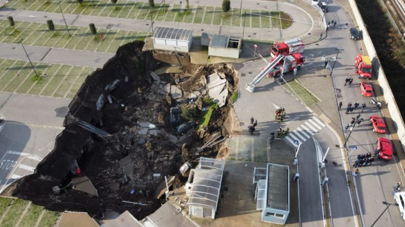 Esta vista aérea muestra un socavón en el estacionamiento del hospital Ospedale del Mare, Italia, donde la gente acudía por pruebas de covid-19. Se formó en la madrugada del 8 de enero de 2021, y destruyó algunos vehículos.