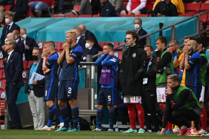 Los jugadores de Finlandia reaccionan después de que el mediocampista danés Christian Eriksen se derrumbara en el campo durante el partido de fútbol.